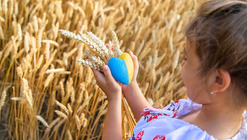 Girl holding heart shape with wheat crop