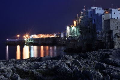 Illuminated city against clear sky at night