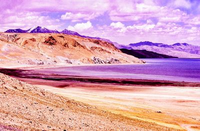 Scenic view of sea and mountains against sky