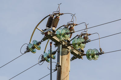 Low angle view of electricity pylon against sky