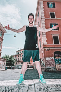 Full length portrait of young man in city against sky