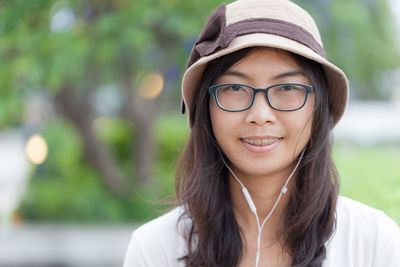 Close-up portrait of smiling young woman wearing headphones