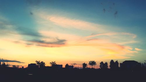 Silhouette cityscape against sky during sunset