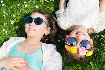 Portrait of happy friends relaxing on grass