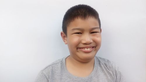 Portrait of smiling boy against white background