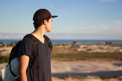 Close-up of man wearing sunglasses standing on beach