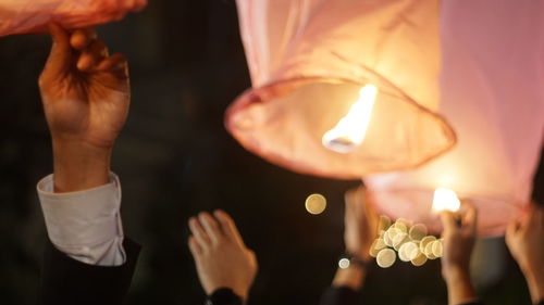 Midsection of woman holding burning candles