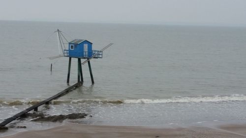 Lifeguard hut on beach against sky