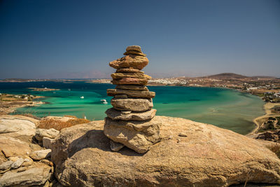 Stack of rocks on beach against clear sky