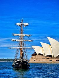 Sailboat in harbor against blue sky