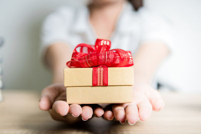 Close-up of human hand holding red box