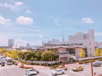 Traffic on city street by buildings against sky