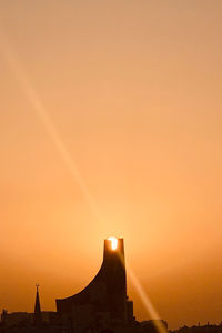 Silhouette of building against sky during sunset