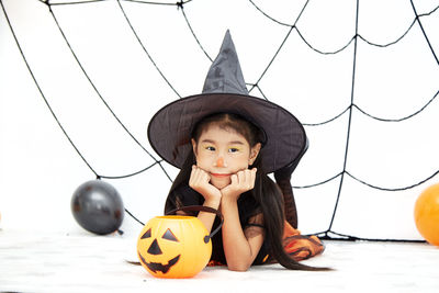 Portrait of cute boy with arms raised during halloween
