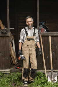 Full length portrait of man standing against graffiti