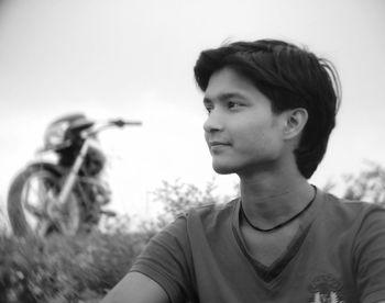 Portrait of young man looking away against sky