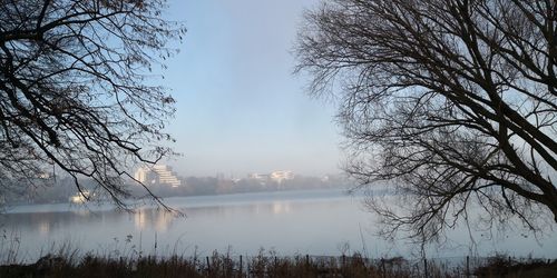 Scenic view of lake against sky at foggy weather