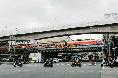 People on road against sky in city