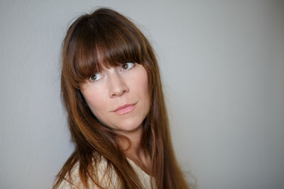 Portrait of young woman against white background