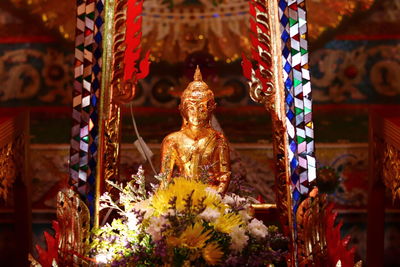 A golden color buddha statue with some decoration