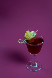 Close-up of wineglass on pink background