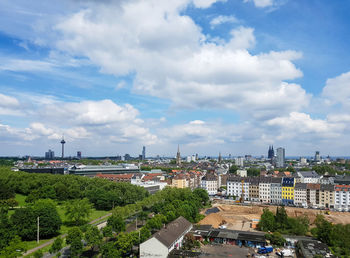 Buildings in city against cloudy sky