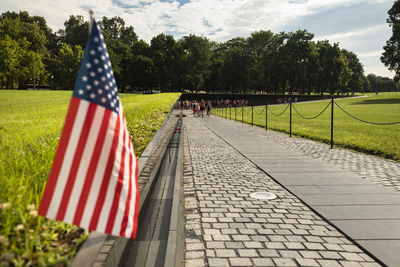 Scenic view of flag on footpath against sky