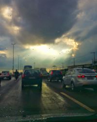 Cars on road against sky during rainy season