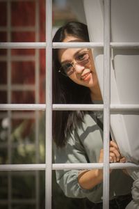 Young woman looking through window