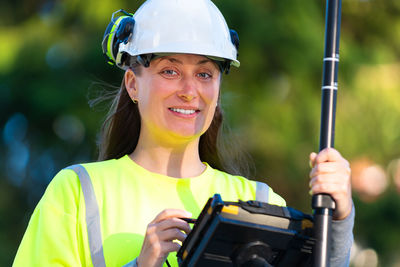 Portrait of a smiling young woman holding camera