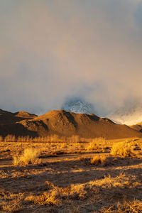 Desert valley brown hills and clouds obscuring the snowy sierra nevada mountains