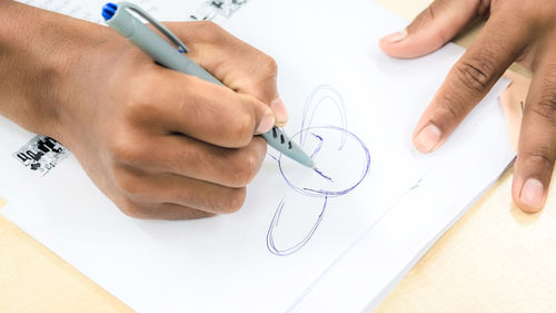 Cropped image of person making drawing on paper 