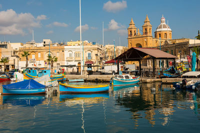 View of church at waterfront against cloudy sky