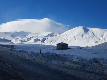 Scenic view of snowcapped mountains against blue sky