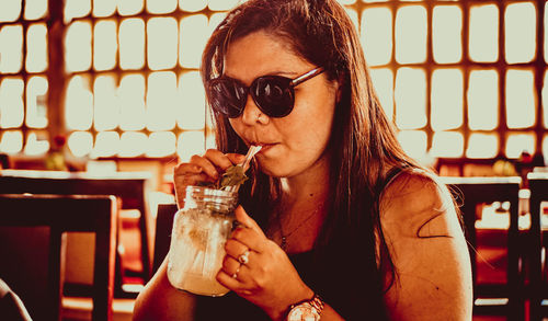 Woman drinking smoothie at restaurant