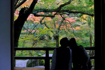 Low section of silhouette people standing by window