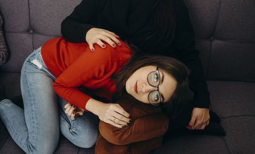 High angle view of woman sitting on sofa at home