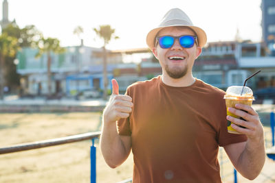 Portrait of man wearing sunglasses standing outdoors