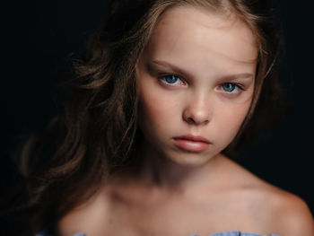 Portrait of beautiful young woman against black background