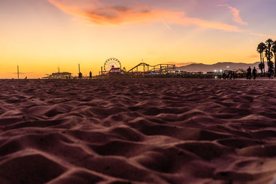 Surface level of beach against sky during sunset
