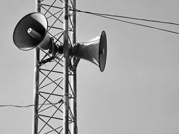 Low angle view of electricity pylon against clear sky