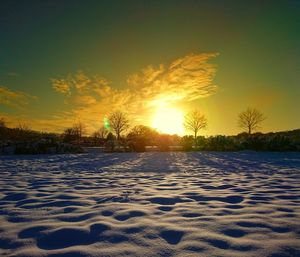 Scenic view of snow covered landscape against sky during sunset