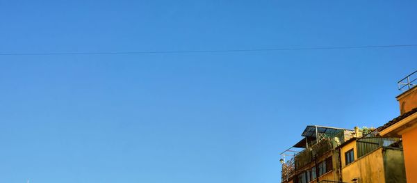 Low angle view of buildings against clear blue sky