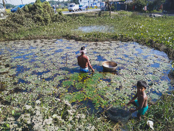 High angle view of people on field by lake