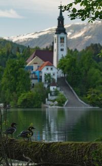 View of building by lake against sky