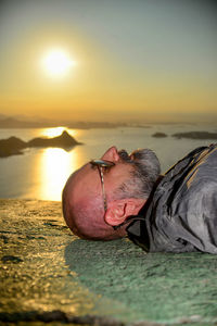 Portrait of man on beach against sky during sunset