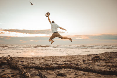 Full length of man standing on beach against sky