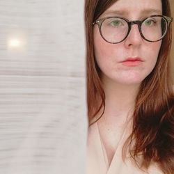 Close-up of young woman wearing eyeglasses looking away