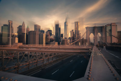 Modern buildings in city against sky during sunset