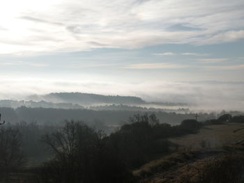 Scenic view of landscape against sky during foggy weather